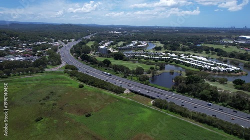 Road Traffic Over Pacific Motorway Near Firth Park In Mudgeeraba, Queensland, Australia. Aerial Drone Shot