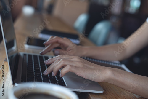 Close up, woman hand typing on laptop computer, working remotely in coffee shop, digital nomad, modern business lifestyle, online job concept