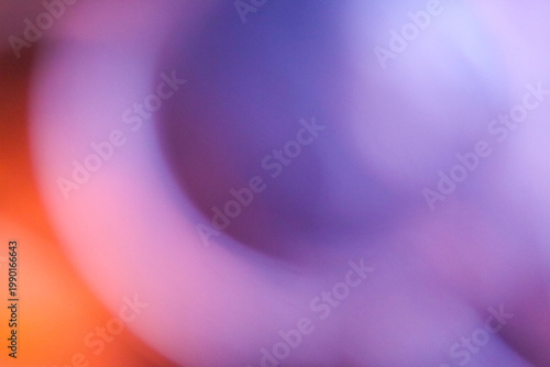 Abstract circular gradient background with a vibrant blend of deep purple, violet, and a bright orange light flare. Smooth blurred texture with organic curved shapes and moody atmospheric lighting