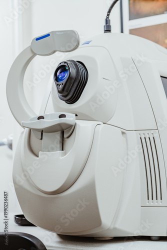 Close up of professional eye examination device in medical center. Detailed view of the headrest and lens of a modern white ophthalmic scanning machine.