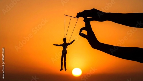 Silhouette hand holding puppet against vivid orange sunset backdrop