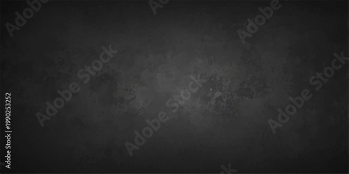 A dark vintage grunge wall texture with a grey aged stone pattern provides a blank dirty concrete surface for an empty black backdrop design
