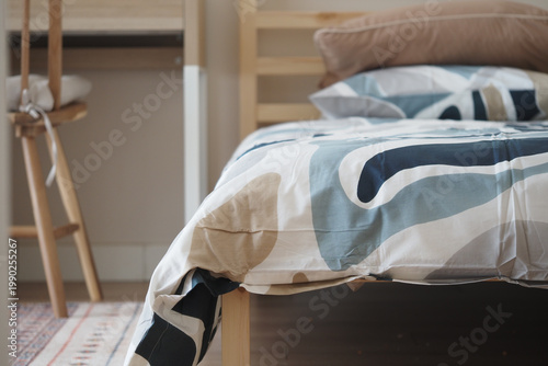 Tableau sur toile Warm bedding on a wooden bed in a simple room