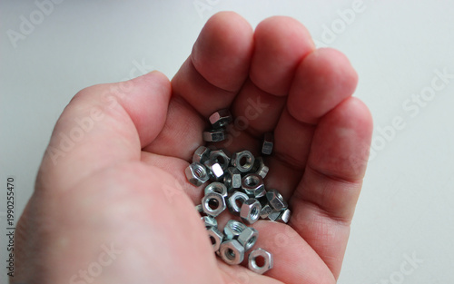 Fotografie A man's tightly clasped hand with small nuts clamped in it