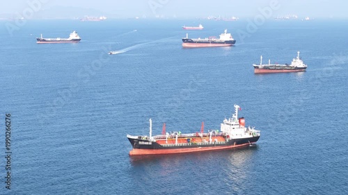 fast patrol boat LPG gas and oil tanker ships anchored in the ocean, with a fast patrol boat in the foreground. Global energy transport, war energy crisis, and Strait of Hormuz blockade