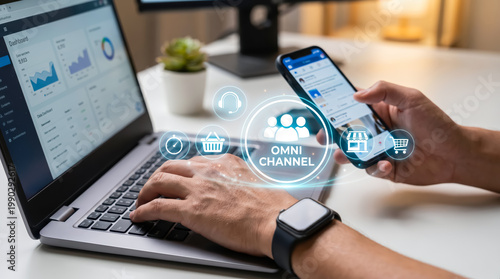 Person working on laptop and smartphone with omnichannel marketing icons for digital business strategy