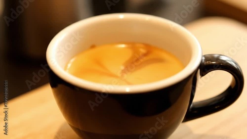 Close-up of a perfectly prepared dark coffee with intricate latte art in a sleek ceramic cup, emphasizing rich flavor and comforting warmth