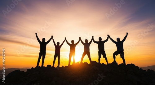 Silhouetted group celebrating success on a mountain peak at sunset