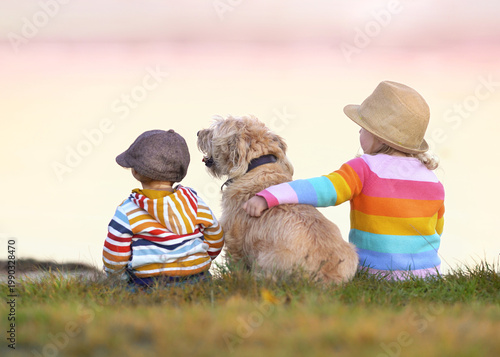 children with their dog sitting on the beach in spring season