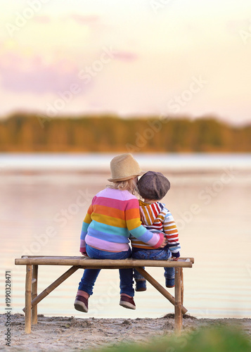 young couple sitting on bench near the lake in spring