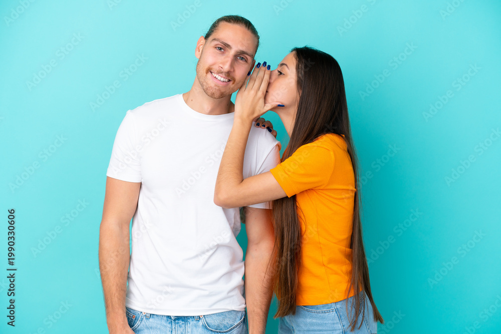 Naklejka premium Young caucasian couple isolated on blue background whispering something