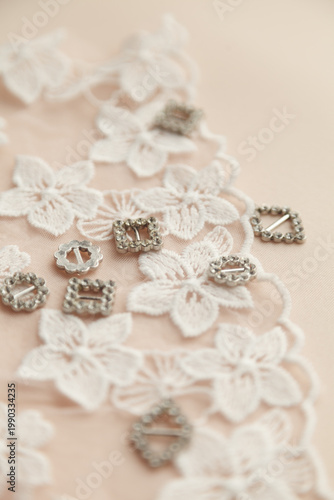 A close-up photo of tailor's tools: white flower lace,  decorations. Photo grain added.