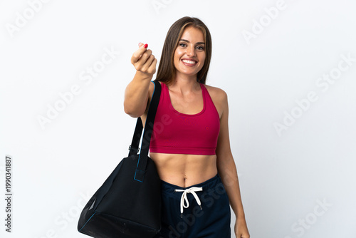 Young sport Uruguayan woman with sport bag isolated on white background making money gesture