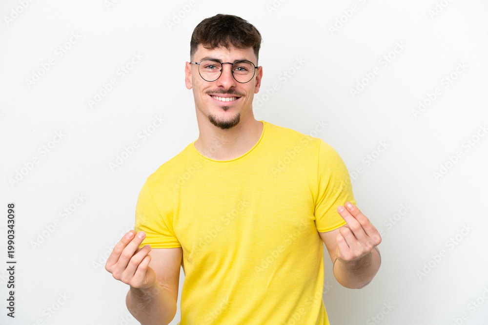 Naklejka premium Young caucasian handsome man isolated on white background making money gesture