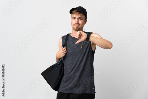 Sport blonde man isolated on white background showing thumb down with negative expression