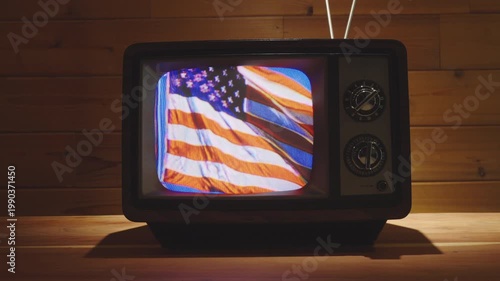 American flag waving in the wind on an old retro 80's television set.