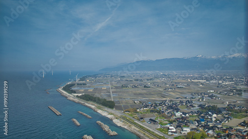 Fotografie 少し霞のかかった早春の下新川海岸の沿岸や離岸堤や防波堤や防風林などの様子