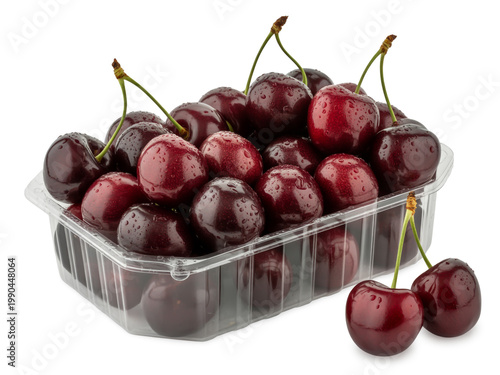 Fresh dark red cherries in a metallic container with a few loose fruits beside it