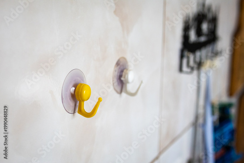 Fotografia Two suction cup hooks stick to a tiled wall with shallow focus