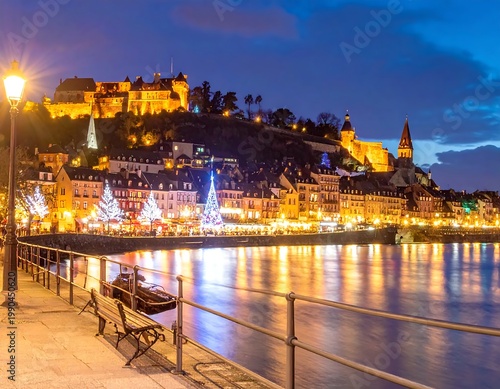 Vianden Castle And Old Town At Night With Christmas Decorations And River Reflections In Luxembourg