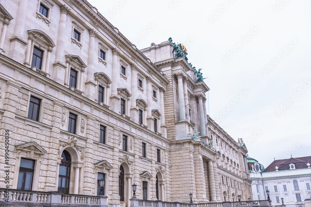 Fototapeta premium Detailed low-angle view of the ornate Neue Burg wing facade at Hofburg Palace in Vienna.