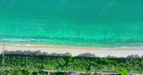 Aerial view of Coastal Nature with Lush Green Edge. Minimalist coastal landscape with gentle surf rolling onto a pristine sandy beach, perfect for travel and relaxation themes