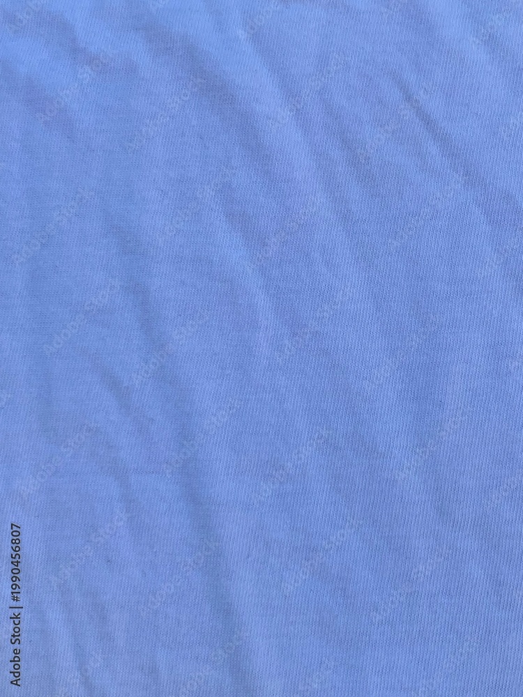 Obraz premium Soft blue cotton fabric texture background featuring delicate folds and natural shadows that create a clean minimalist surface for creative design projects