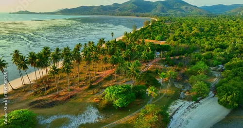 A mesmerizing aerial view of Laem Haad sandbar reveals dragon scale patterns beneath shallow waters. Tourists stroll along the white strip linking two island, forming a surreal tropical scene.