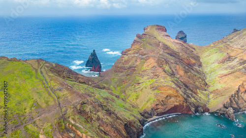 Dramatic coastal cliffs and vibrant Atlantic waters at Ponta de São Lourenço, Madeira. A hiker's paradise under an overcast sky.