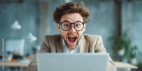 Entrepreneur celebrating successful funding approval while reading email on laptop in bright modern office environment representing business growth and opportunity concept
