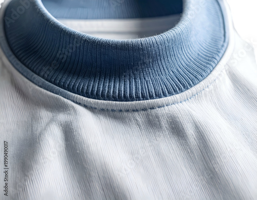 Close-up of a light blue ribbed collar on a white textured garment