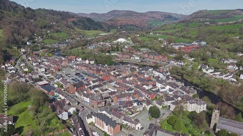 Aerial view, the town centre of Llangollen with its historic buildings and streets set against the backdrop of the Dee Valley hills in Wales.
