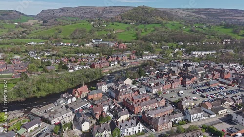 Aerial view shows the town centre of Llangollen and the flowing River Dee with a backdrop of lush green hills in the North Wales countryside