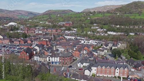 Aerial view shows the historic stone buildings of Llangollen town centre within the scenic landscape of North Wales