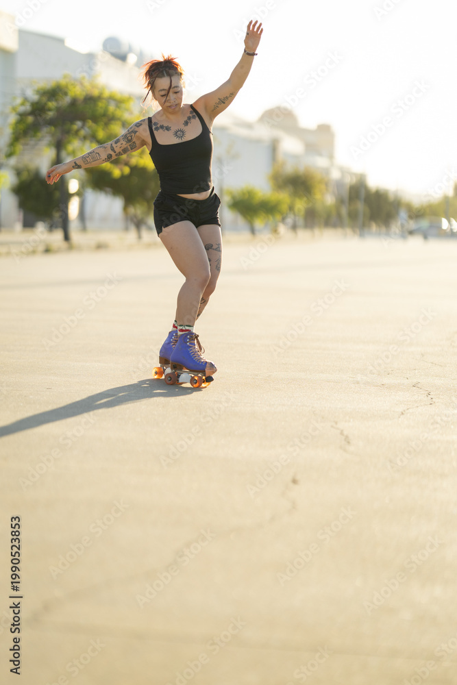 Fototapeta premium Woman roller skating enjoying outdoor activity at sunset