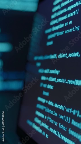 Close up of laptop screen with programming code in dark environment, blue glowing code lines on display and background. Data science software development and coding concept. Vertical video