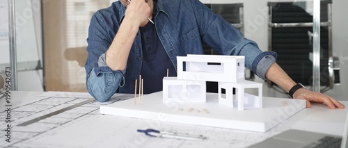 Photos Male architect in glasses at a contemporary office working on a white architectu