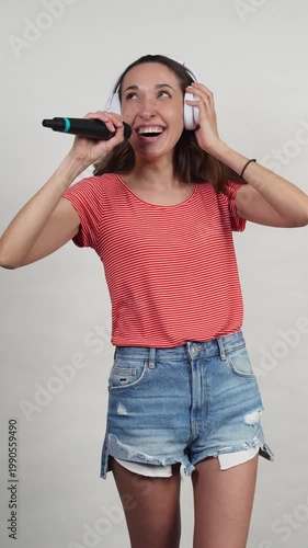 Joyful woman singing and dancing with headphones
