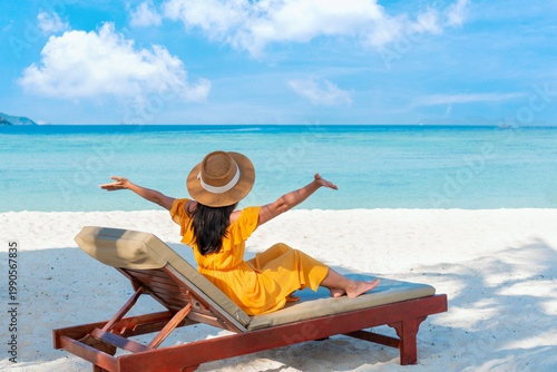 Happy Asian traveler woman relaxing at the beach. Summer and vacation concept. Copy space