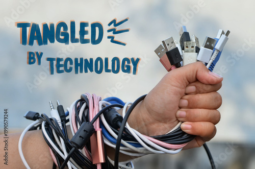 Hand holding tangled USB cables with handwritten text about digital overload and technology addiction