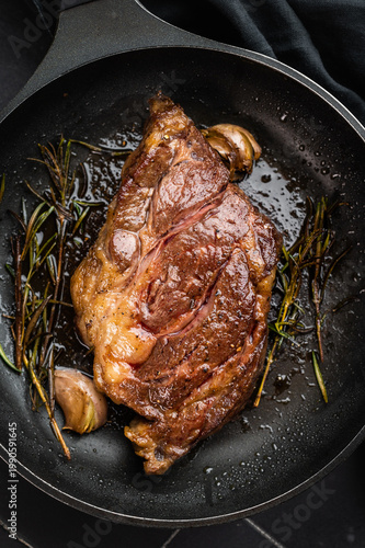 Foto Seared beef chuck eye roll steak in skillet with rosemary and butter