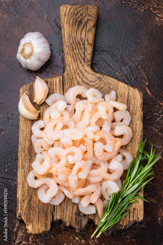Schilderij op canvas Baby shrimp pile on rustic cutting board, cocktail shrimp ingredient for salads, tapas, pasta and gourmet seafood recipes