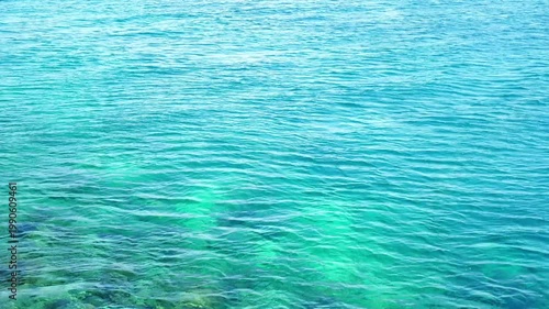 Turquoise and Teal Tropical Sea Surface with Gentle Ripples Over Coral Reef - 4K footage