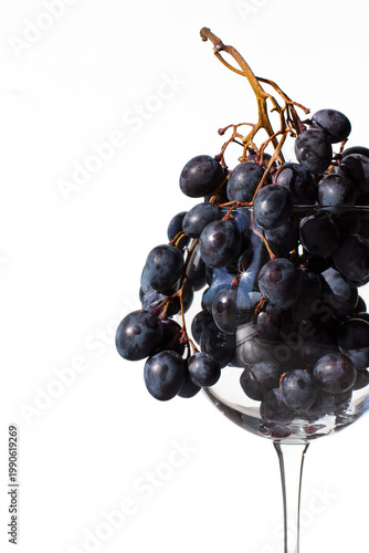 Grapes close-up. Bunch of grapes in a glass on a white background