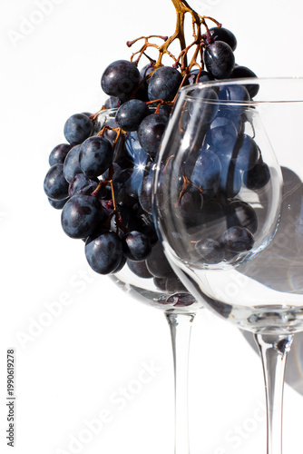 From grapes to wine. Winemaking. Empty glass and glass with red grapes