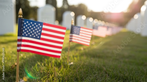 Small American flags placed on graves in a cemetery during sunset, honoring fallen soldiers and Memorial Day