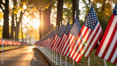 Patriotic scene with American flags in perspective along a tree-lined path during autumn sunset