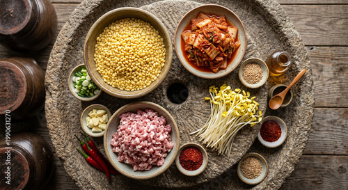 Overhead flat lay of Bindaetteok ingredients on rough grinding stone texture