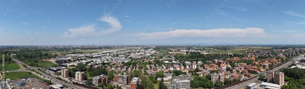 Obraz premium Cityscape Panorama: An expansive panorama showcases an urban landscape, blending residential and commercial areas, Peschiera Borromeo, Milan, Italy, 