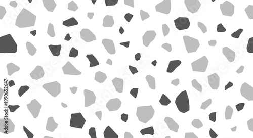 Scattered grey and dark grey irregular shapes on a white background